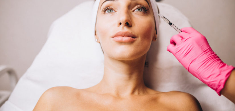 Cosmetologist making injections on a face of a woman in a beauty salon